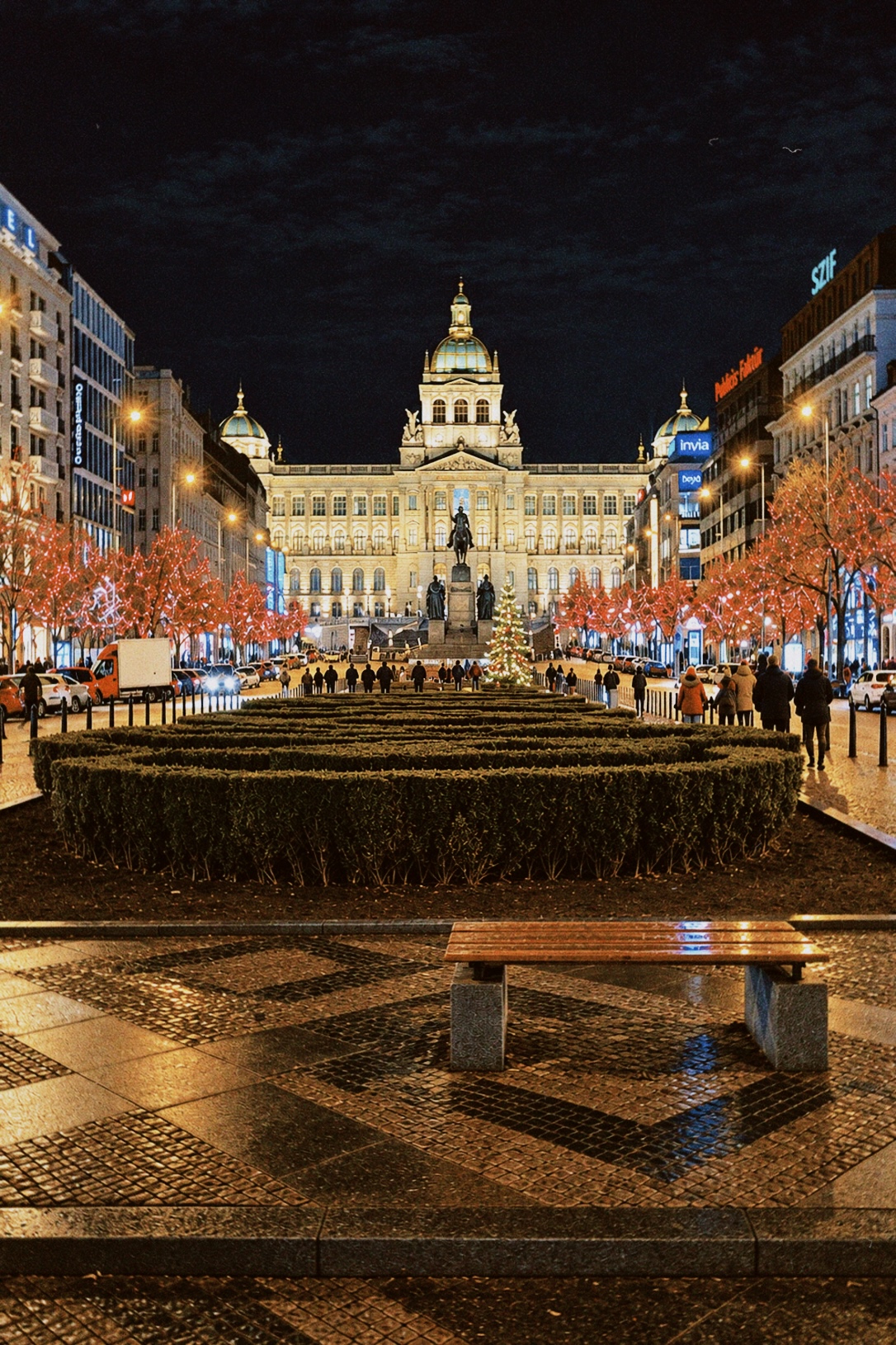 Wenceslas Square at night in Prague with illuminated historic buildings and Christmas lights.